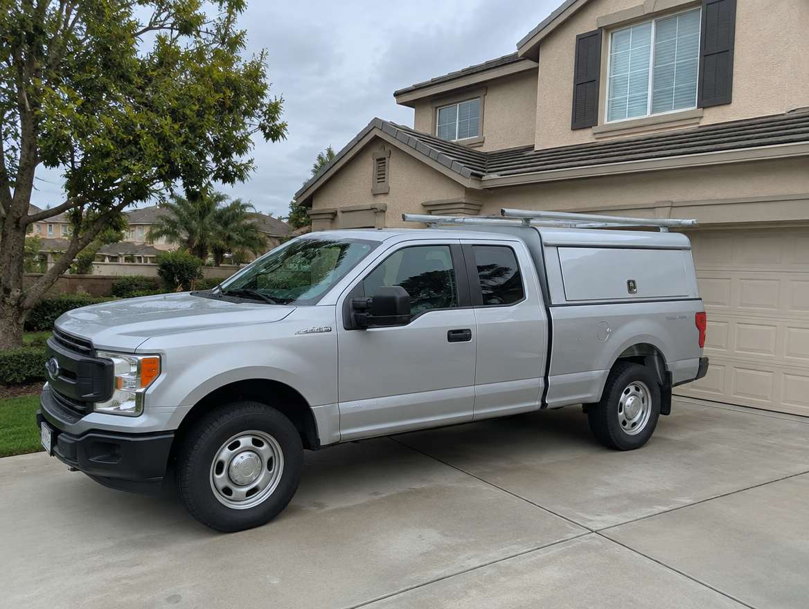 An unmarked plumbing service van parked at a home in Brea, California