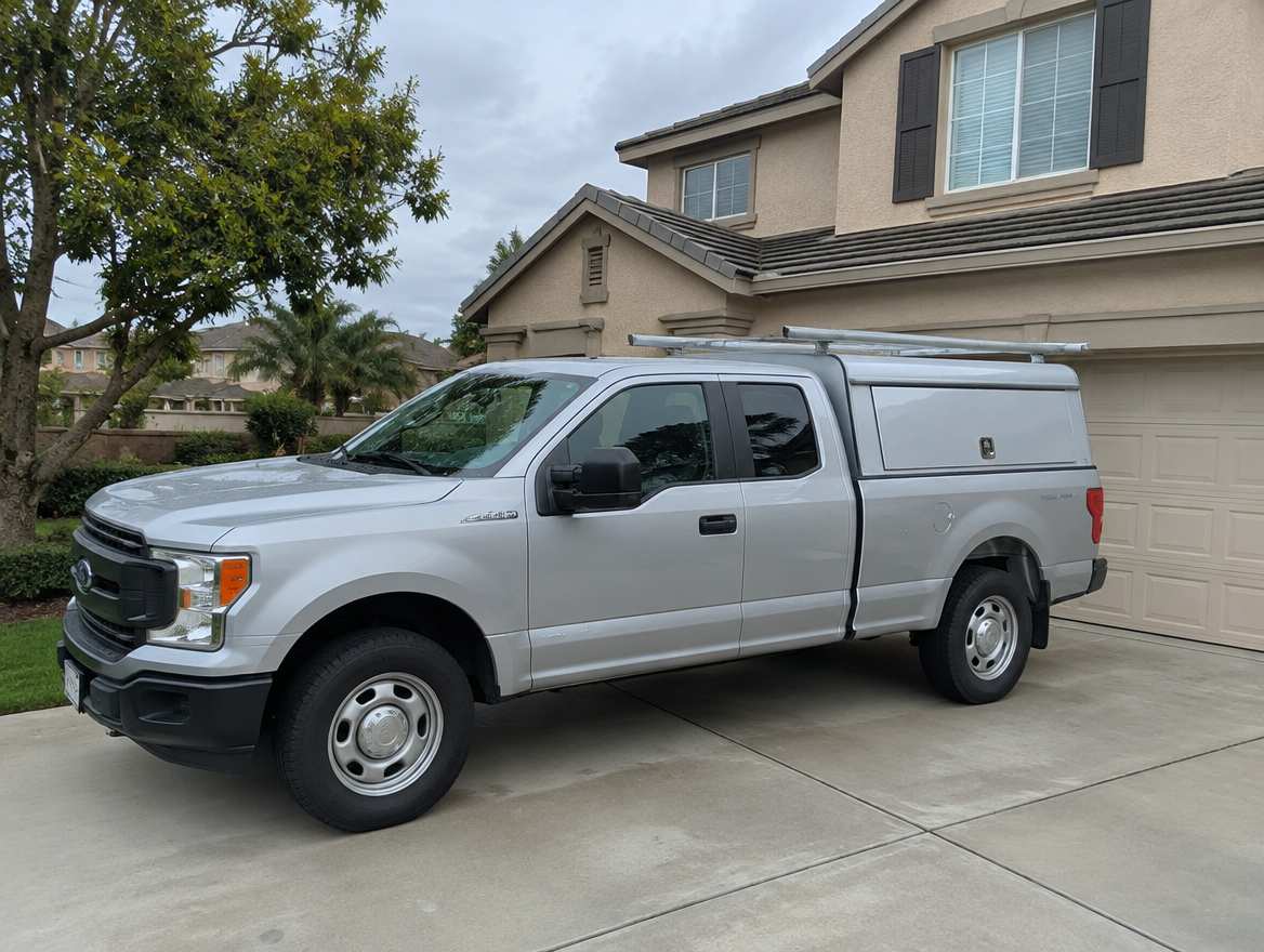 An unmarked plumbing service van parked at a home in Brea, California