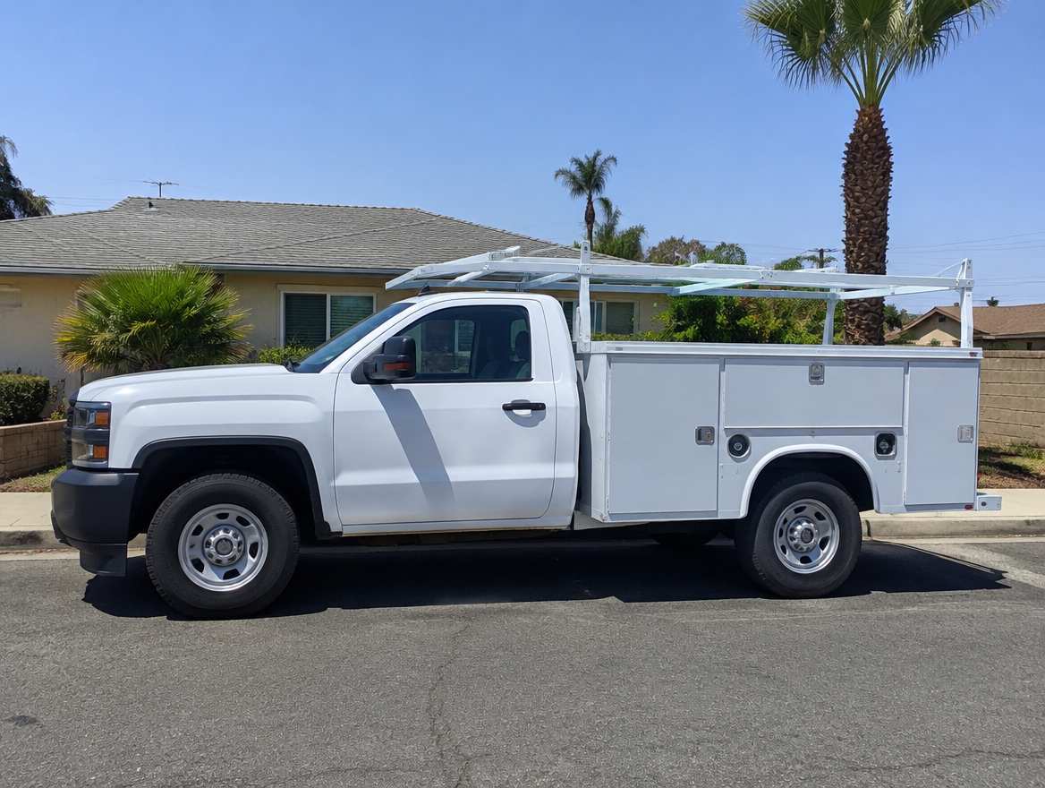 An unmarked plumbing service van parked at a home in Fullerton, California