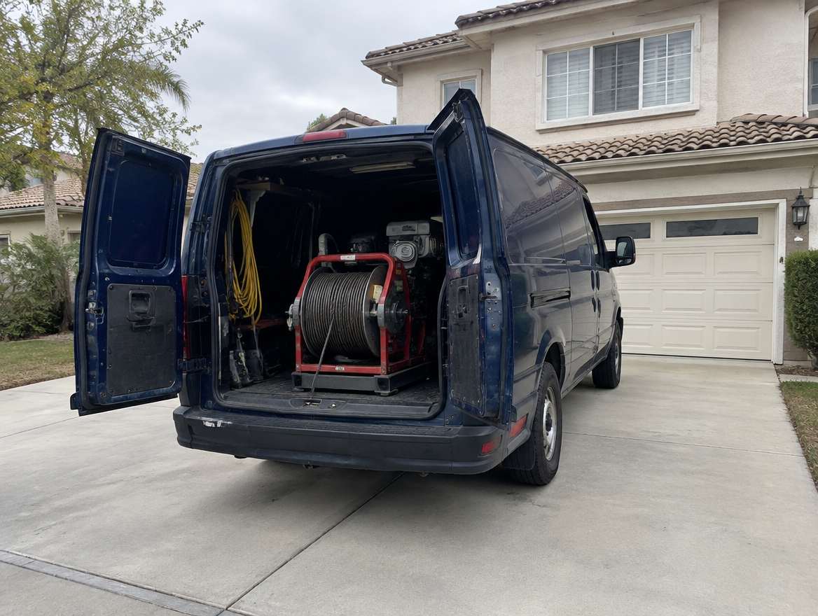 An unmarked plumbing service van parked at a home in Fullerton, California