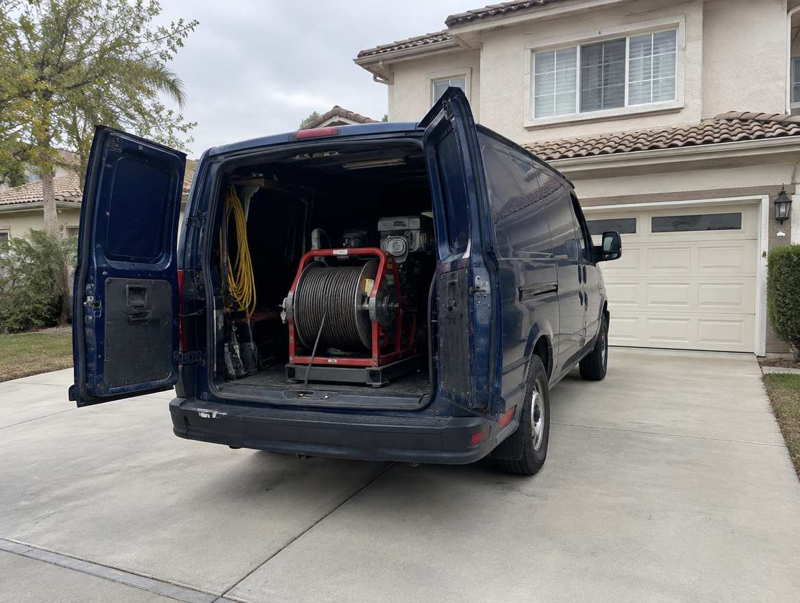 An unmarked plumbing service van parked at a home in Fullerton, California