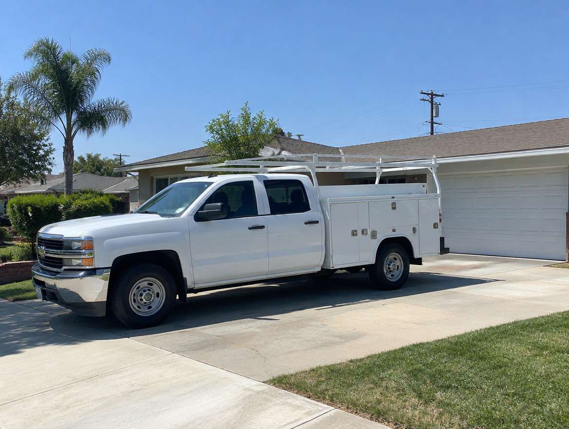 An unmarked plumbing service van parked at a home in Stanton, California